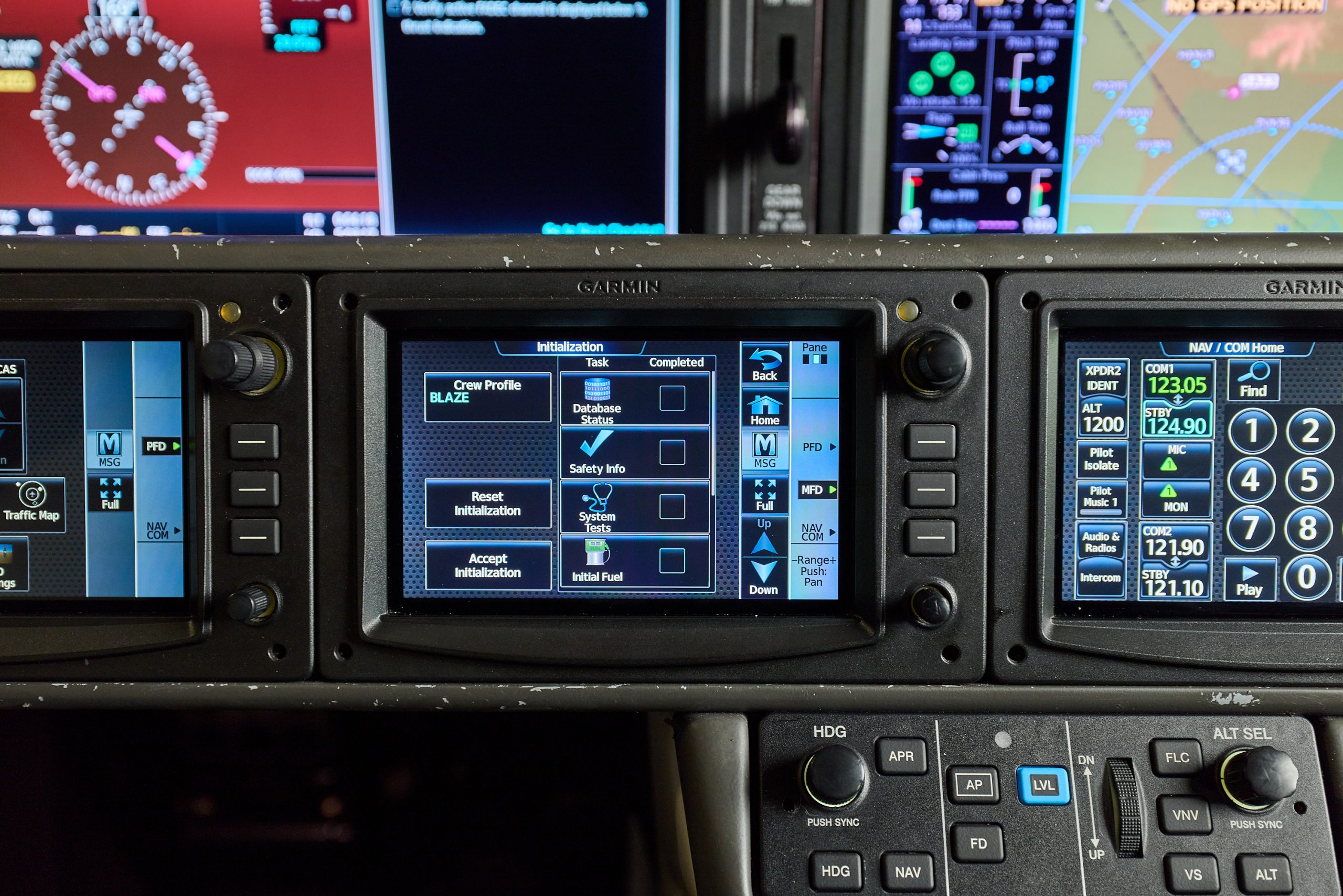 Garmin aircraft avionics panel with digital flight displays, radio controls, and navigation screens in a modern cockpit