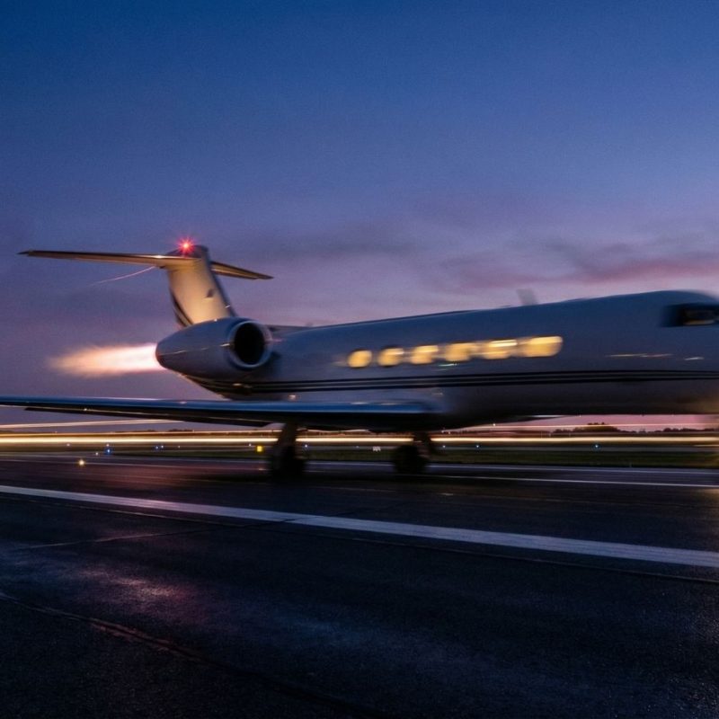 Luxury private jet taxiing on runway at sunset, business aviation at twilight